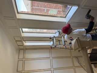 Painter finishing stairwell wall paneling